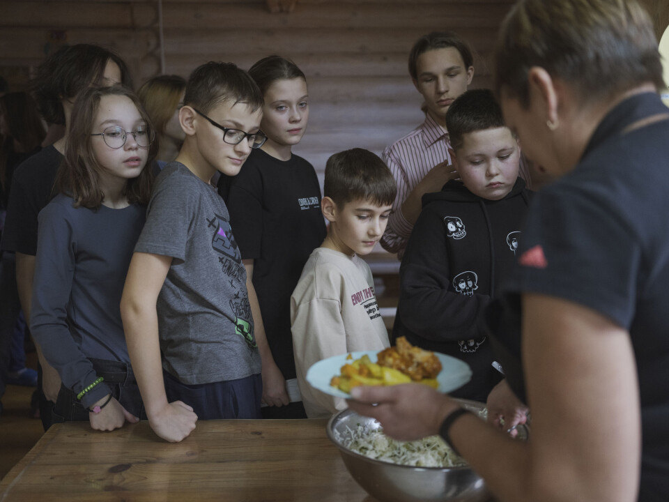 En gruppe barn står i kø for å få lunsj.