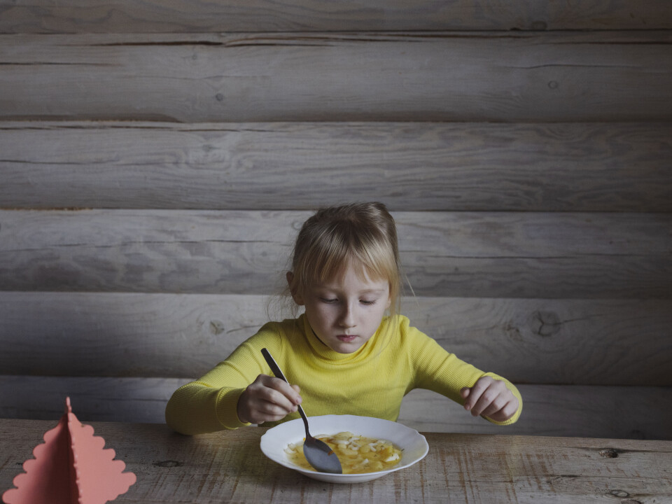 Sofia på 7 år spiser suppe i matsalen.