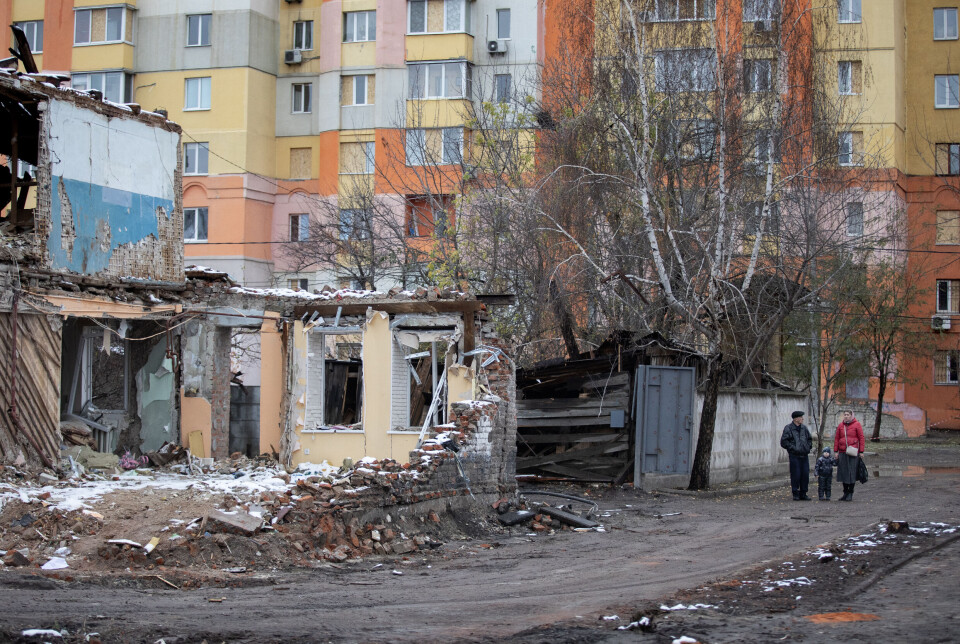 Til tross for at Kharkiv ligger tett på fronten, og mottar russiske missiler og glidebomber hver eneste uke, forsøker folk å opprettholde en viss normalitet. Her ser naboer på de store ødeleggelsene etter at et russisk missil traff en politistasjon i sentrum av byen i november i fjor.