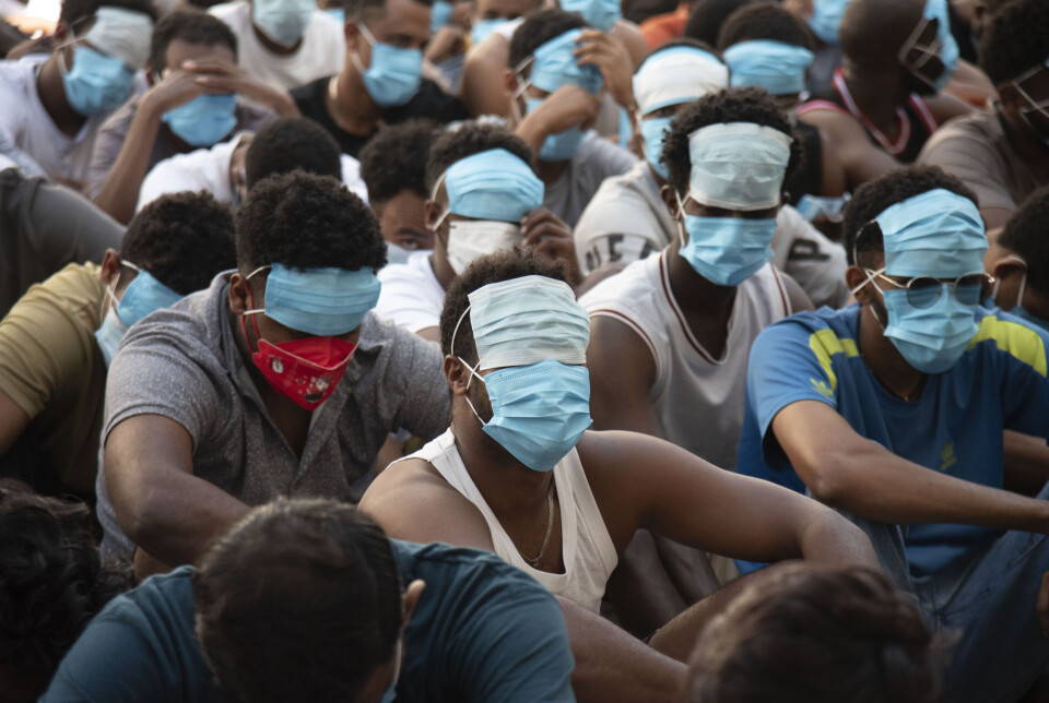 Personer fra Kina, Vietnam og Etiopia, som har vært utsatt for menneskehandel og tvunget til å jobbe i svindelsentre, sitter med tildekkede ansikter i internering i Myawaddy-distriktet i Øst-Myanmar 26. februar 2025.