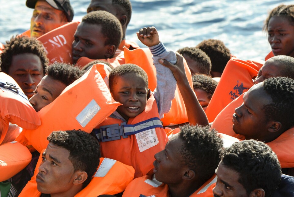 En gummibåt med migranter venter på å bli reddet av den maltesiske organisasjonen Moas og Italias Røde Kors utenfor den libyske kysten.