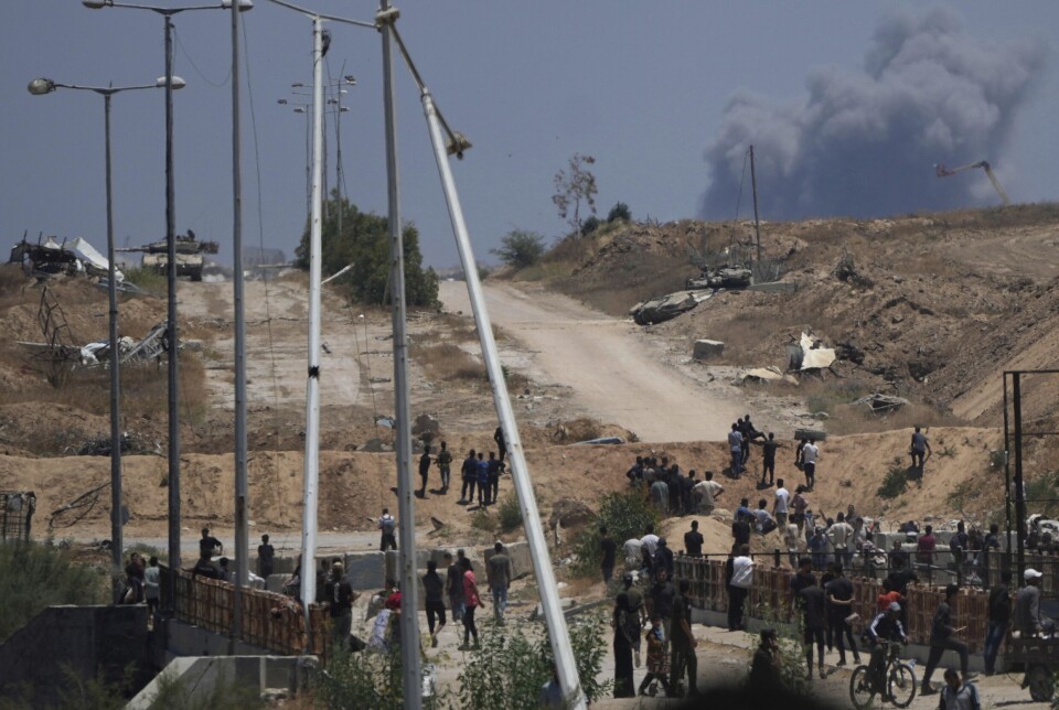 Israelske stridsvogner sees plassert mens røyk stiger opp i bakgrunnen i sørlige Gaza, sett fra et distribusjonssenter for humanitær hjelp drevet av USA-støttede Gaza Humanitarian Foundation, i Khan Younis, sørlige Gazastripen, torsdag 29. mai 2025.