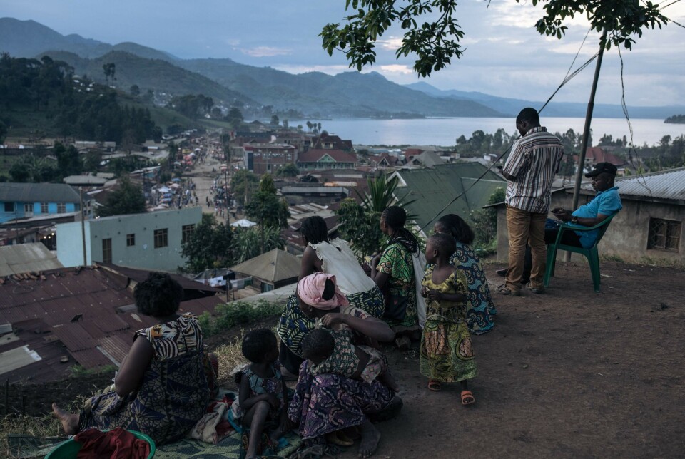 Fordrevne kvinner og barn sitter utenfor en lokal kirke i Minova i Øst-Kongo, der de og over 200 familier søkte tilflukt fra krigshandlingene i mars.