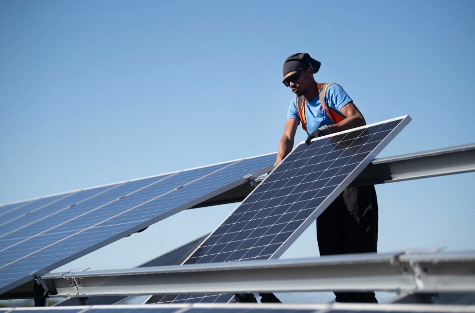 En arbeider monterer solcellepaneler under byggingen av Sør-Afrikas første kommunalt eide solkraftverk utenfor Cape Town 5. juni. Sør-Afrika er ett av Klimainvesteringsfondets åtte kjerneland.