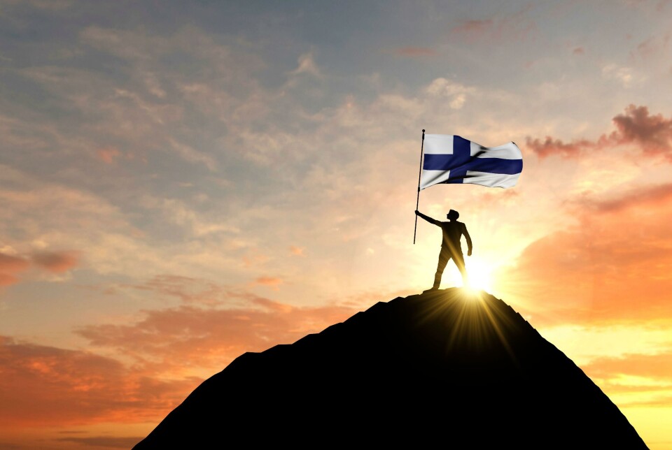 Det er 50 år siden 35 land signerte Helsingforserklæringen, som nå omfatter flere land. Bildet viser en mann som løfter det finske flagget ved morgengry.