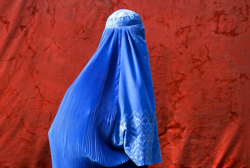 En afghansk kvinne iført burka står langs en vei i Kandahar 29. juli 2025.