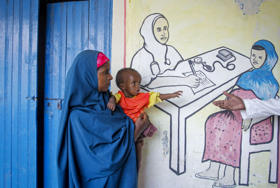 En mor holder sitt underernærte barn ved et ernæringssenter drevet av Action Against Hunger i Mogadishu, Somalia, i 2022.