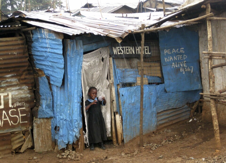 En kenyansk jente leker i døråpningen til et veikrohotell i en av verdens største uformelle bosetninger, Kibera, i hovedstaden Nairobi.