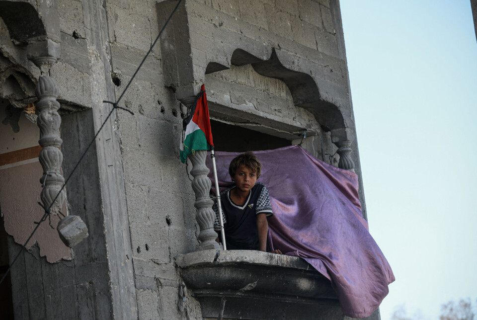 En palestinsk gutt ser ut av vinduet i en utbombet bygning i Belt Lahia, nord på Gazastripen. Familier har returnert dit etter at den skjøre våpenhvilen trådte i kraft 10. oktober.