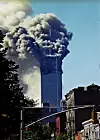 Røyk og flammer fra et av Twin Towers i World Trade Center over bybygninger i New York