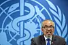 Tedros Adhanom Ghebreyesus taler foran WHOs blå logo under en pressekonferanse.
