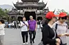Turister foran et tradisjonelt tempelbygg i Vietnam.