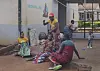 Kvinner sitter og gjør husarbeid utenfor barselavdelingen ved sykehuset i Kasungu i Malawi.