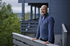 Rune Jansen Hagen står på en terrasse ved et hus i Bergen.
