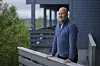 Rune Jansen Hagen står på en terrasse ved et hus i Bergen.