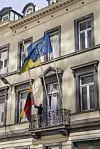 EU- og litauiske flagg henger fra en balkong på en bygård.