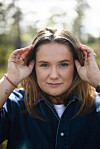 Frøya Skjold Sjursæther står utendørs med hendene ved hodet, foran en uskarp bakgrunn.