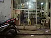 Majdi Majzub sitter inne i et lite rom i Shatila-leiren, sett gjennom et vindu.
