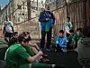 Majdi Majzub snakker til en gruppe gutter som sitter samlet på et sportsanlegg i Shatila-leiren.