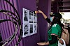 En person setter opp plakater med bilder av savnede personer på en lilla vegg ved Mexico City Stadium.
