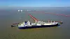 Et LNG-skip ligger ved en terminal med en lang rørledning ut i vannet.