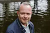 Torben Bjørke-Henriksen står foran vann med mørkt jakkeslag og lys genser.
