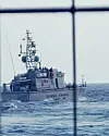 Italiensk kystvaktbåt på havet, sett gjennom et vindu eller gitter.