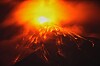 Lava strømmer ut fra krateret på Fuego-vulkanen i et mørkt landskap.