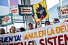 Protesterende holder plakater med krav om skatterettferdighet og gjeldsslette i Sevilla.