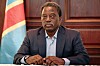 Joseph Kabila sitter ved et bord foran trepanel og et kongolesisk flagg.