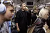 Tett med passasjerer i en T-banevogn, med en mann i mørke klær sentralt.